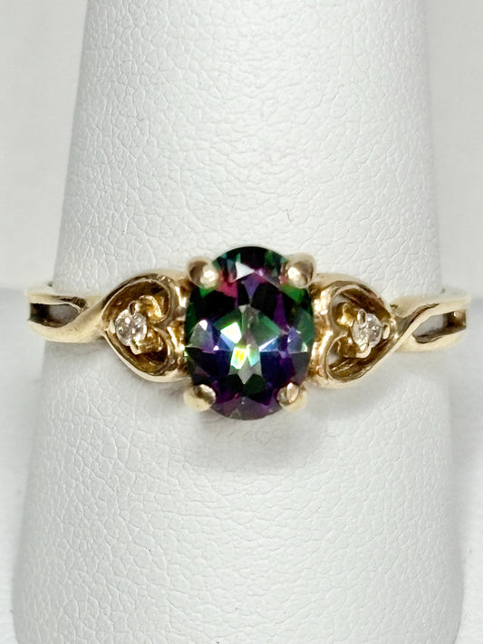 A 10k yellow gold ring with a mystic topaz center stone and two diamonds.