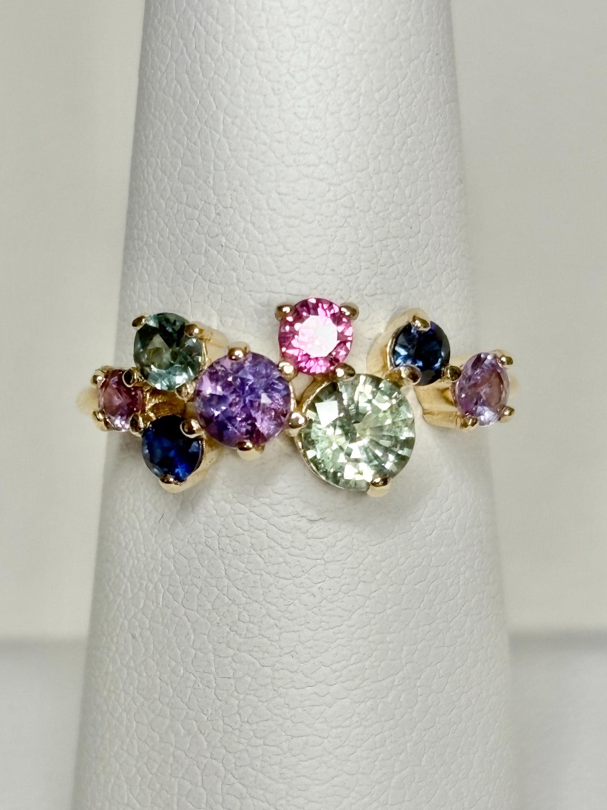 A 10k gold ring with eight round natural sapphires in various colors.