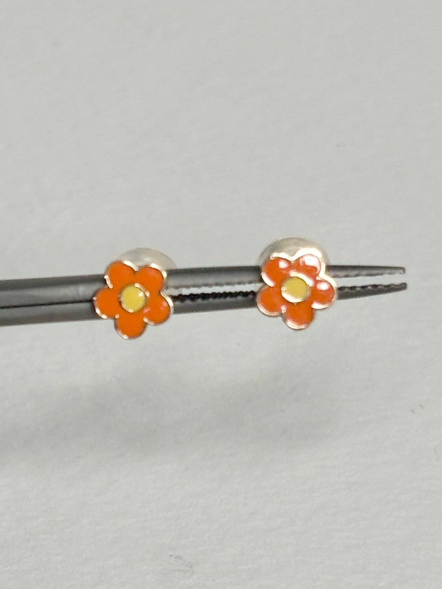 Orange and yellow enamel daisy flower stud earrings in solid 14k gold.