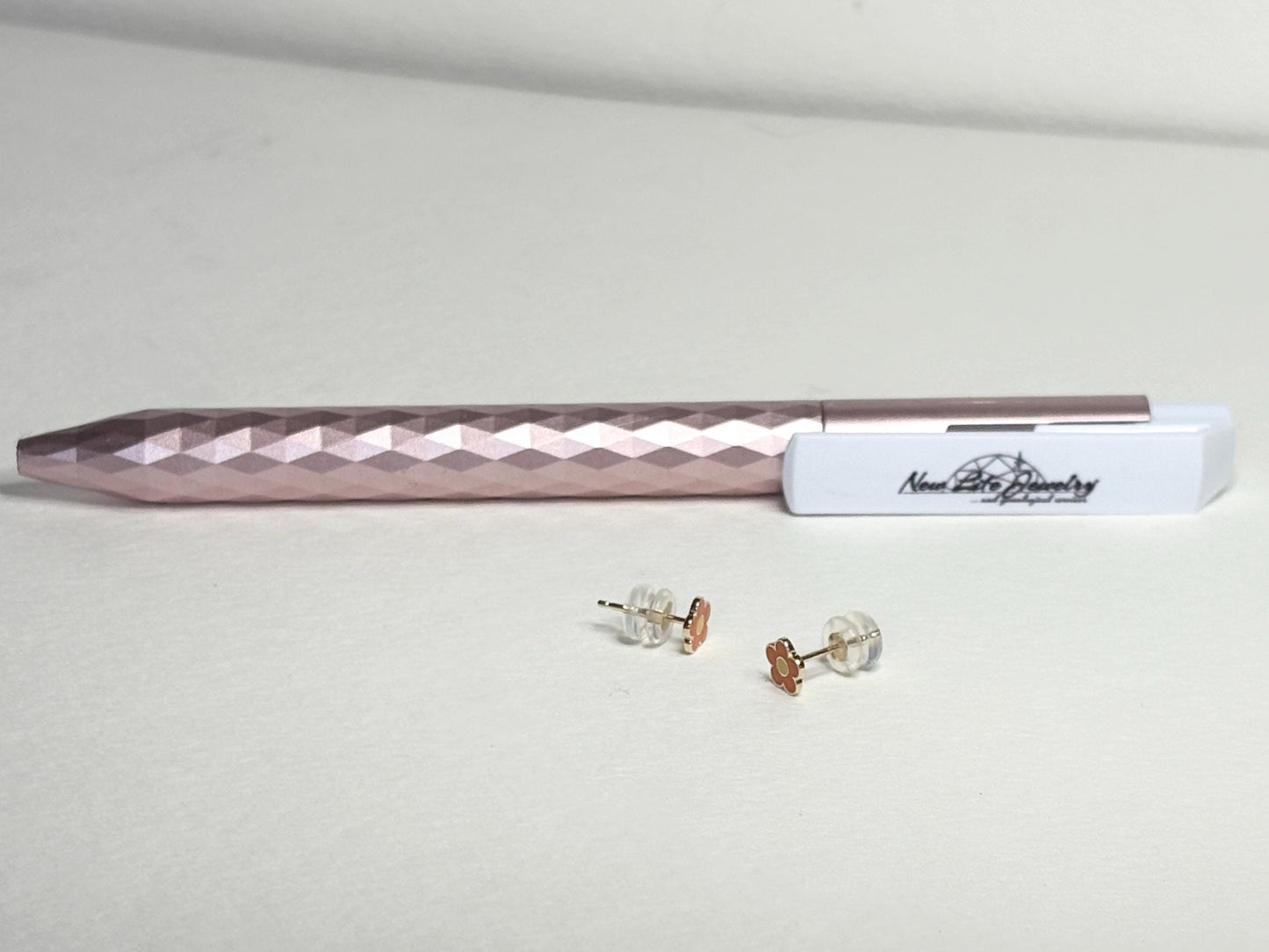 Solid 14k gold daisy stud earrings with orange and yellow enamel.