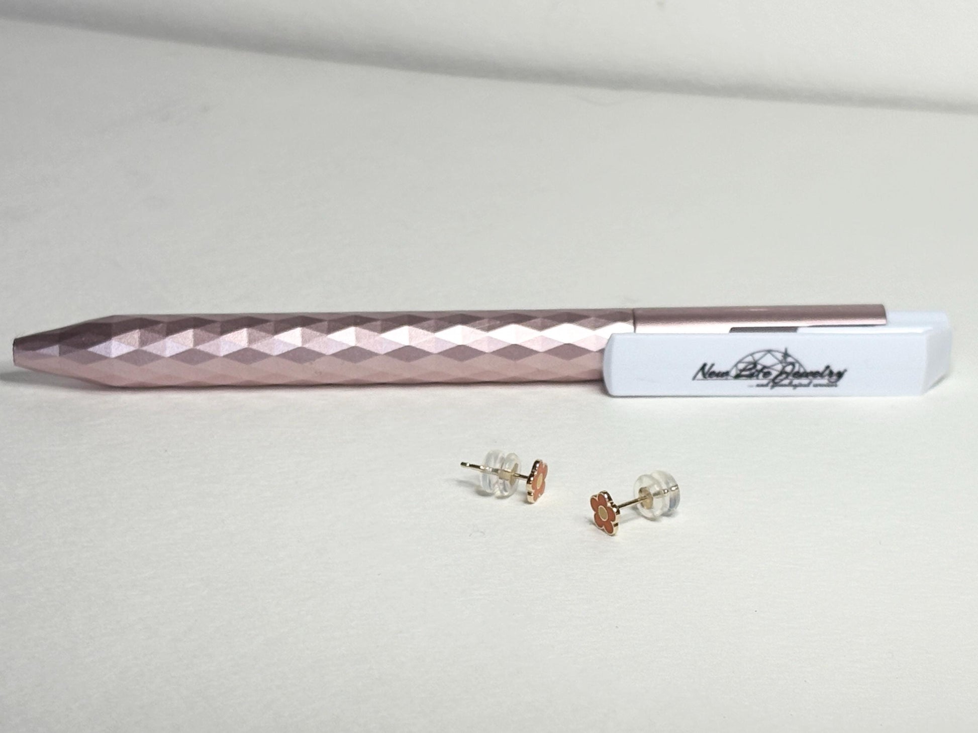 Solid 14k gold daisy stud earrings with orange and yellow enamel.