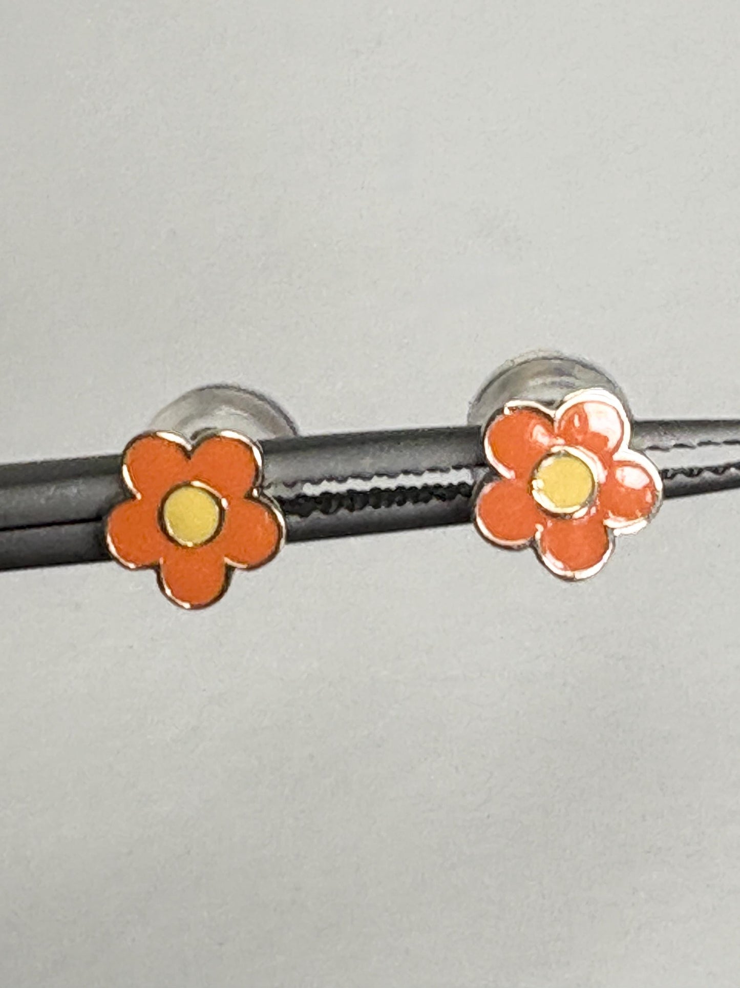 Orange and yellow enamel daisy flower stud earrings in 14k gold.