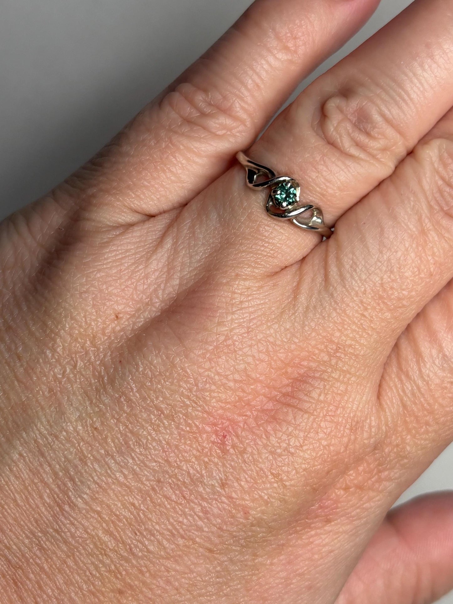 A 10k white gold band ring with a blue-green tourmaline.