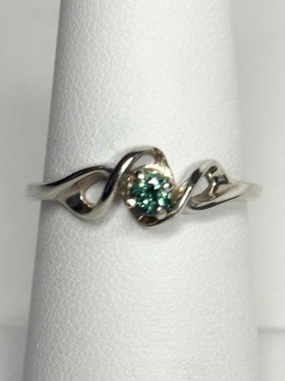 A 10k white gold band ring with a round blue-green tourmaline.
