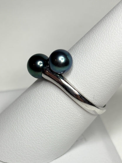 Sterling silver bypass ring with two black cultured Akoya pearls.
