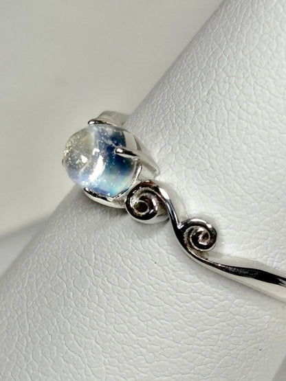 Sterling silver ring with a rainbow moonstone cabochon and swirl design.
