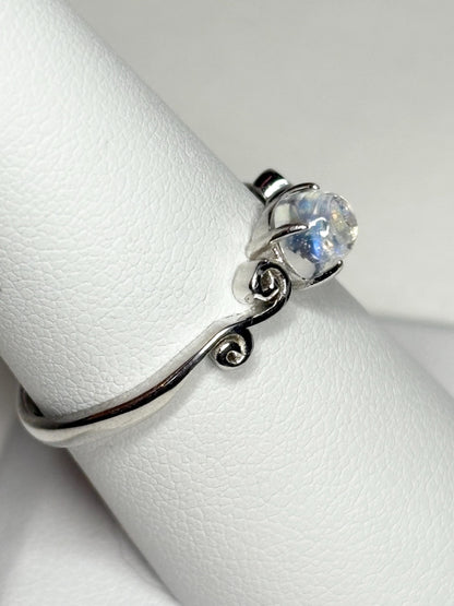 Sterling silver ring with a rainbow moonstone cabochon and swirl design.