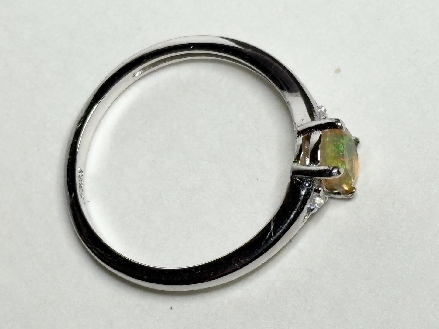 Sterling silver ring with an oval Ethiopian opal and small accent stones.