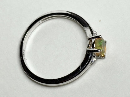 Sterling silver ring with an oval Ethiopian opal and small accent stones.