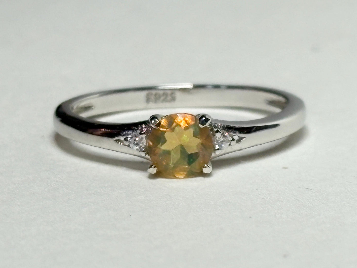 Sterling silver ring with a golden Ethiopian opal and two small diamonds.