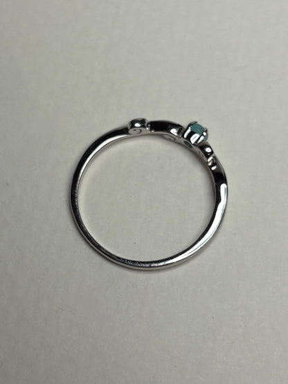 Sterling silver ring with a swirl design and a small blue gemstone.