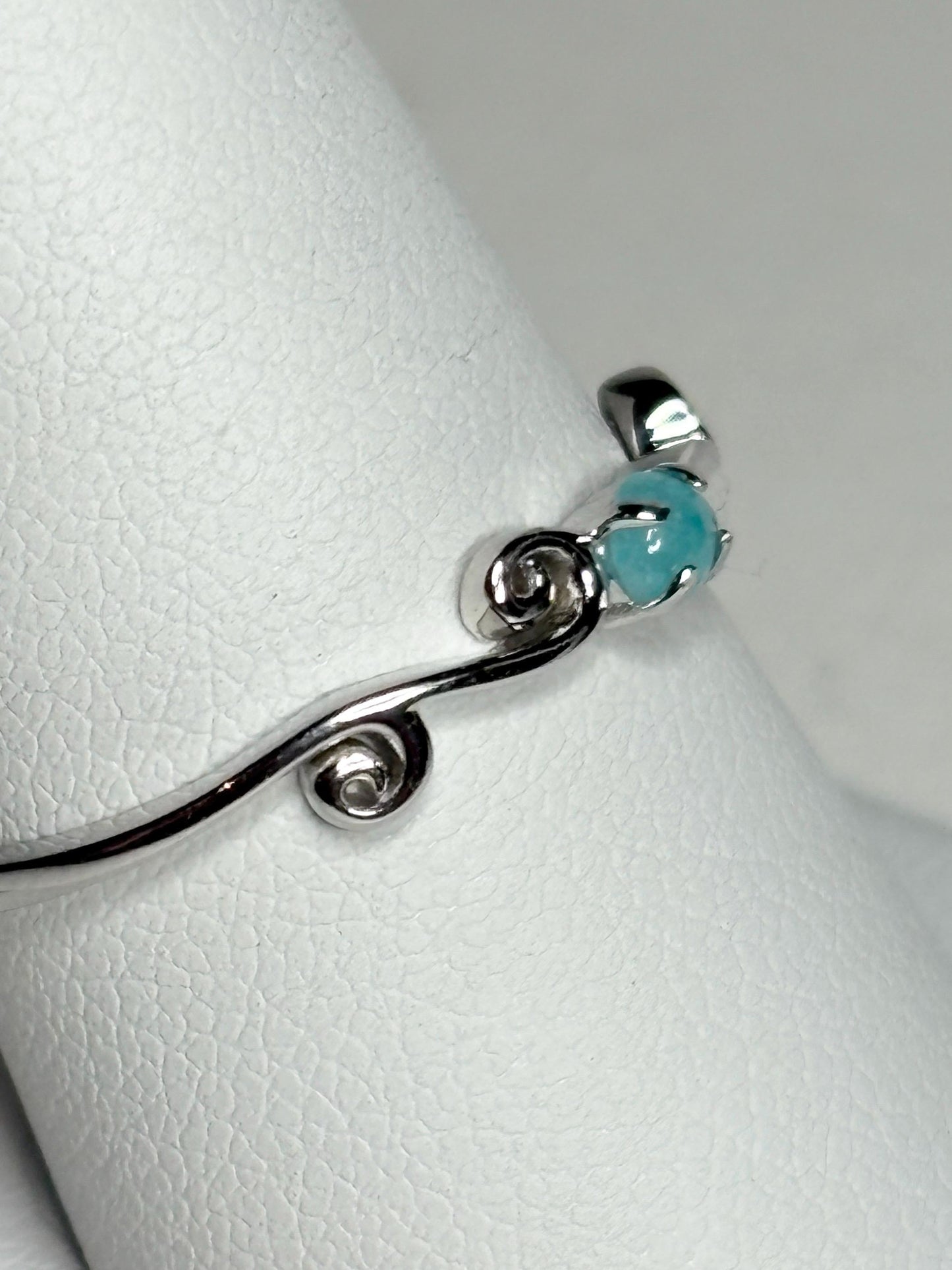 Sterling silver ring with a blue tourmaline and swirl design.