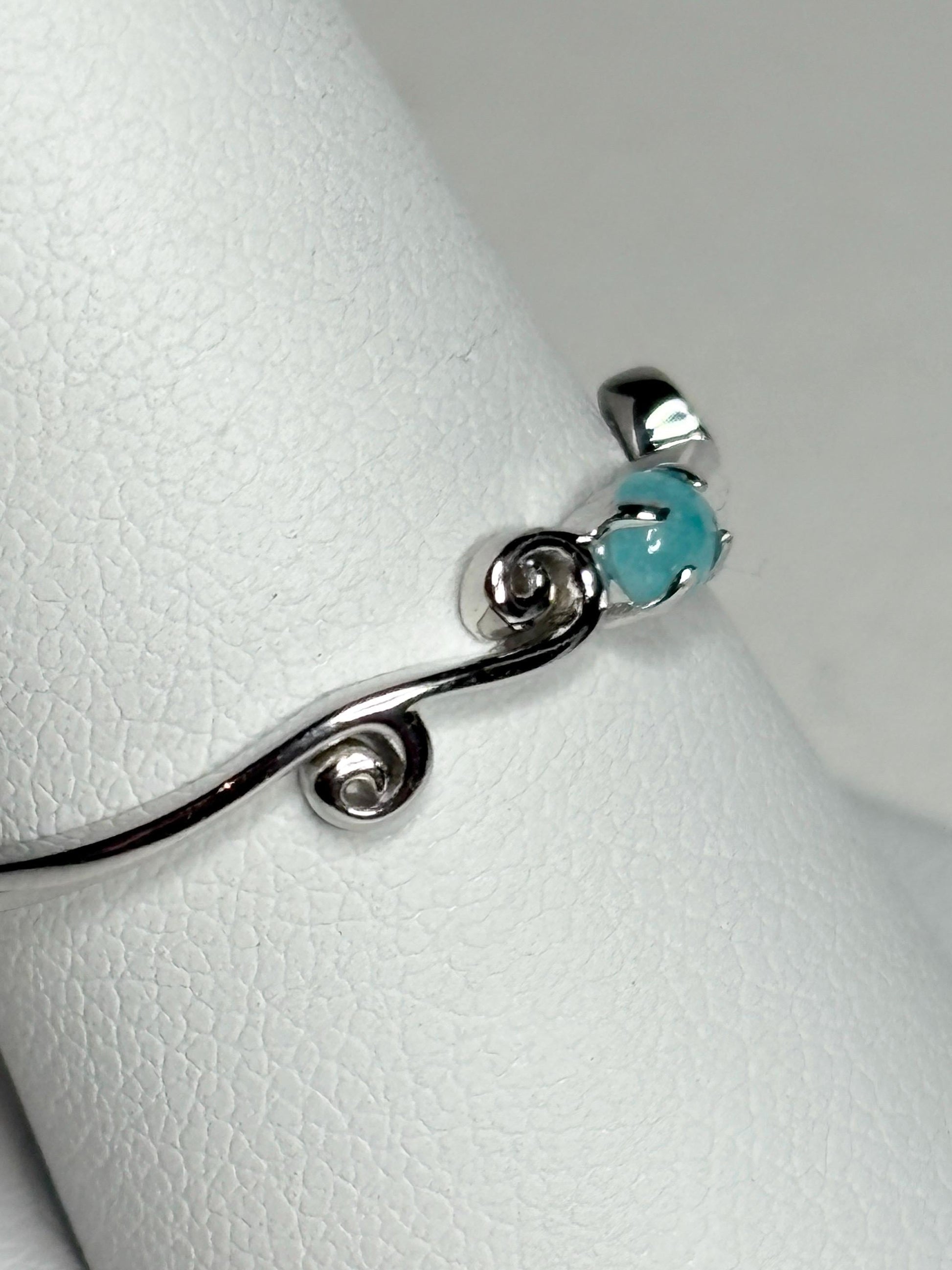 Sterling silver ring with a blue tourmaline and swirl design.