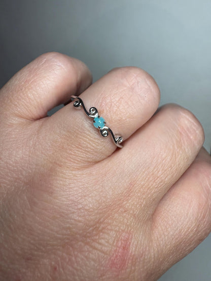 Sterling silver ring with a blue tourmaline and swirl design.