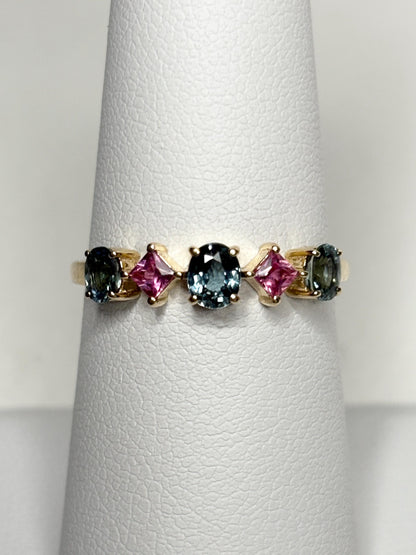 A 9k gold band ring with oval steel blue and square pink sapphires.