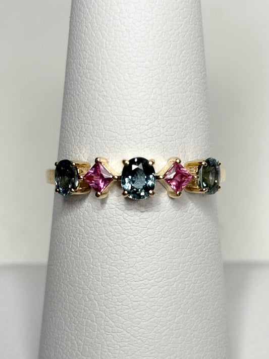 A 9k gold band ring with oval steel blue and square pink sapphires.
