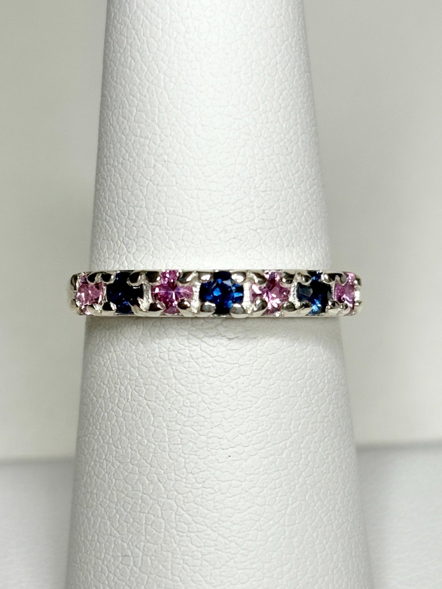 Sterling silver band ring with alternating blue and pink sapphires.