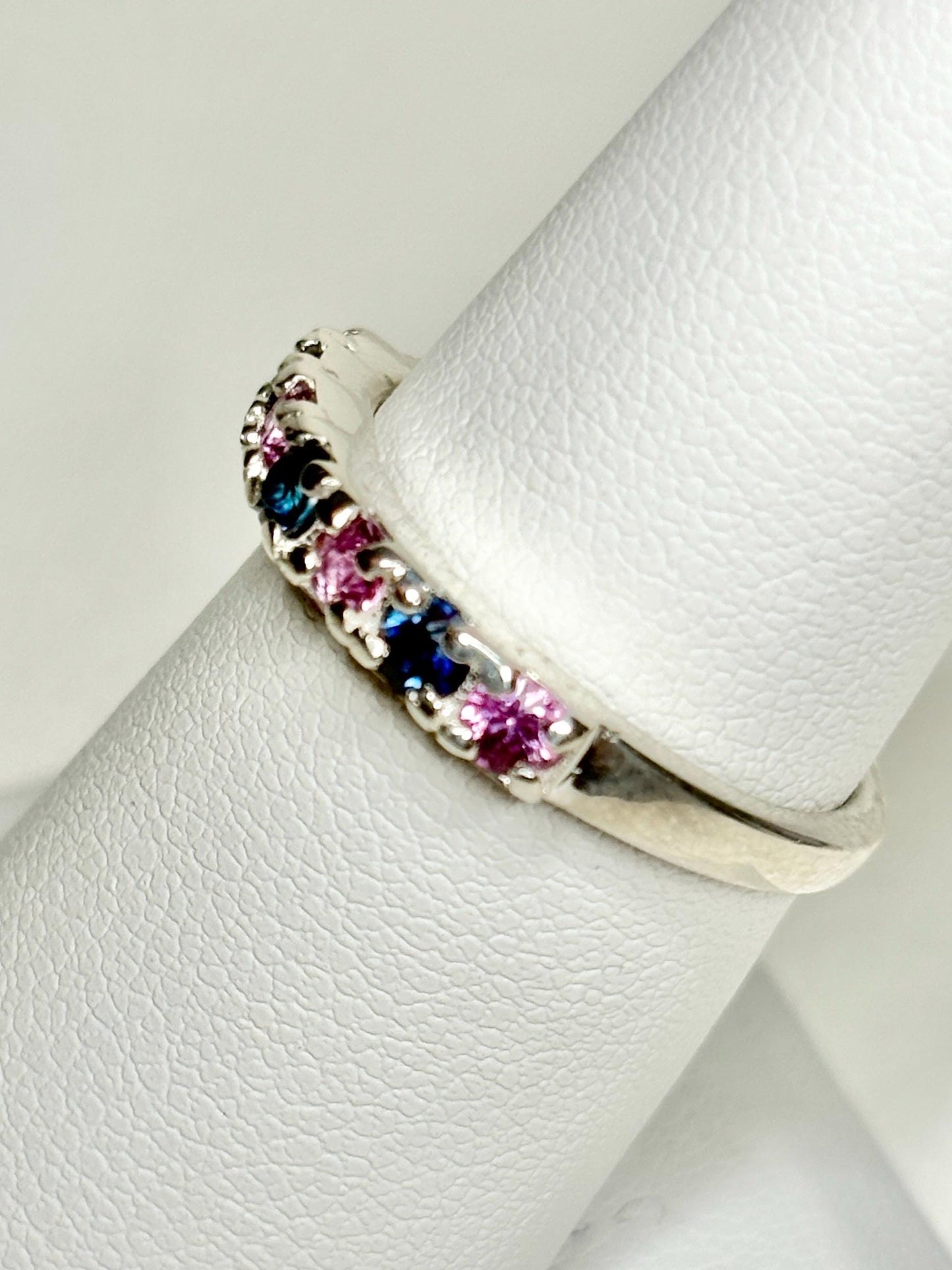 Sterling silver band ring with alternating blue and pink sapphires.