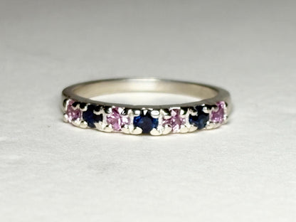 Sterling silver band ring with alternating blue and pink sapphires.