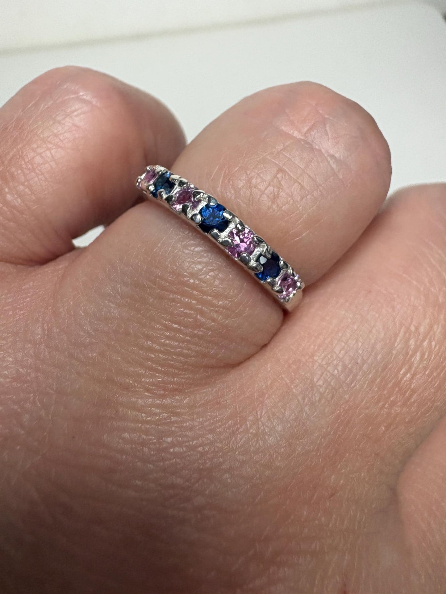 Sterling silver band ring with alternating blue and pink sapphires.