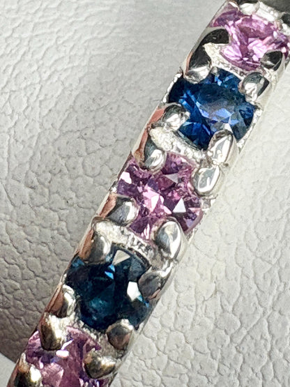Sterling silver band ring with alternating blue and pink sapphires.