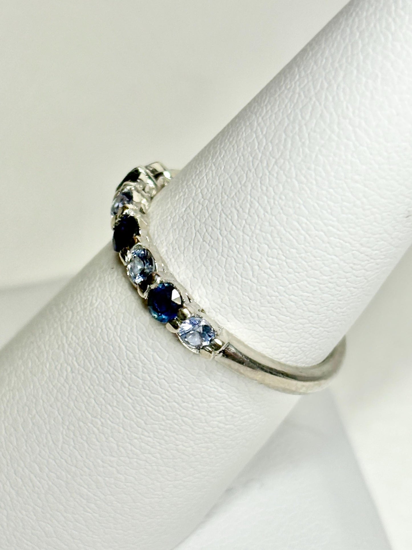Sterling silver band ring with alternating blue and light blue sapphires.