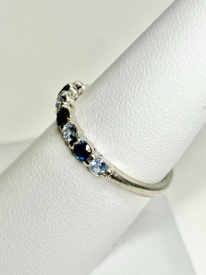 Sterling silver band ring with alternating blue and light blue sapphires.