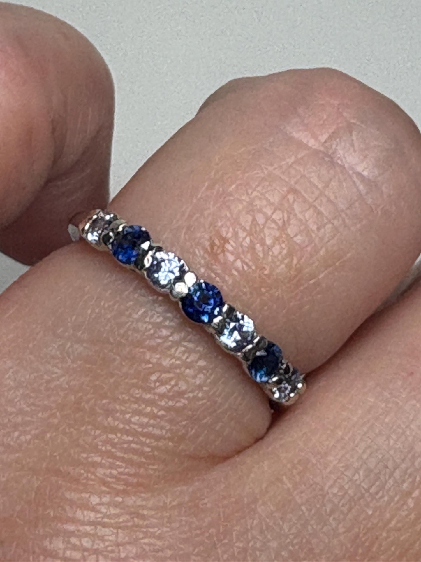 Sterling silver band ring with alternating blue and light blue sapphires.
