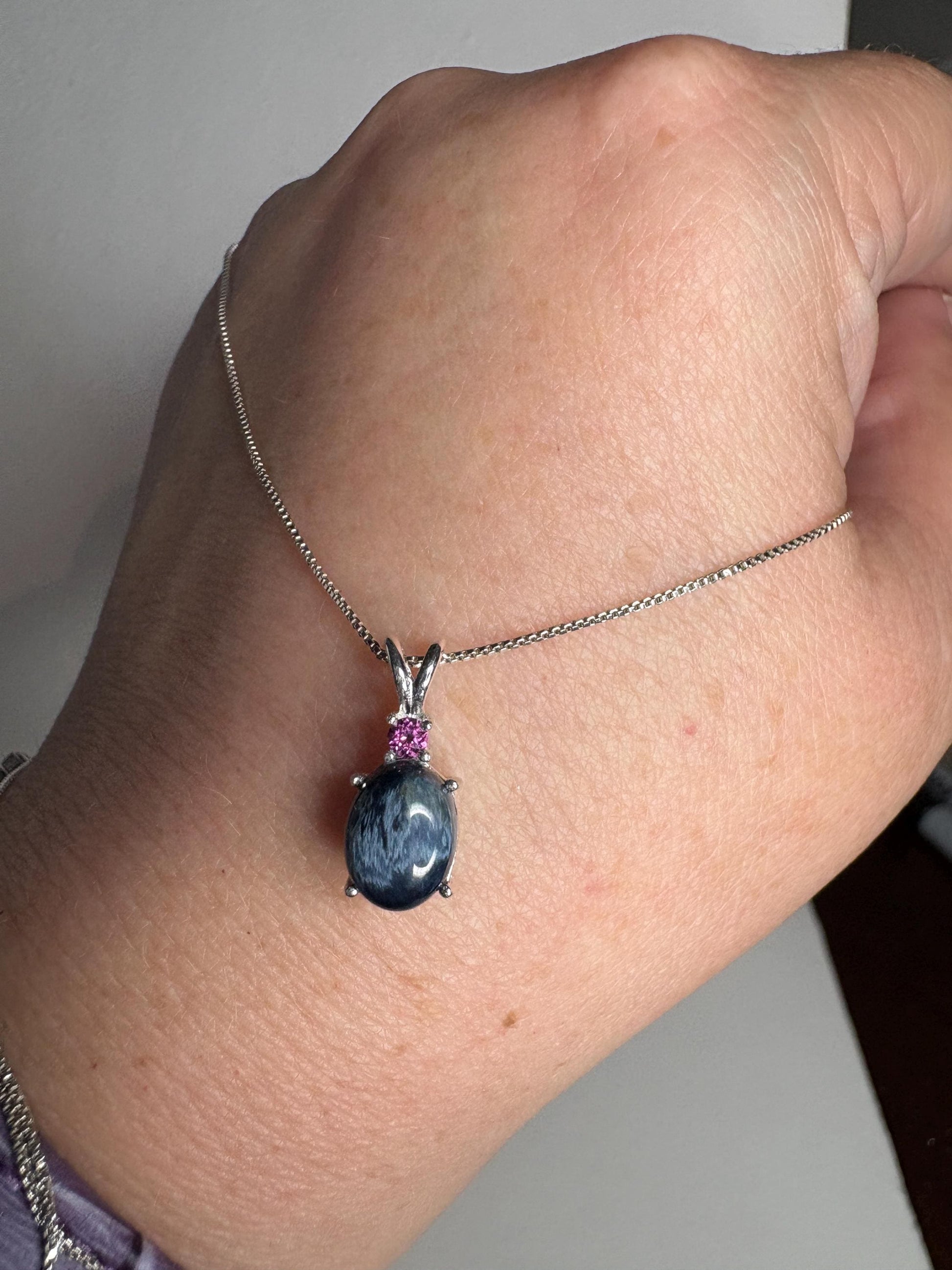 Sterling silver pendant necklace with oval blue pietersite and rhodolite garnet.