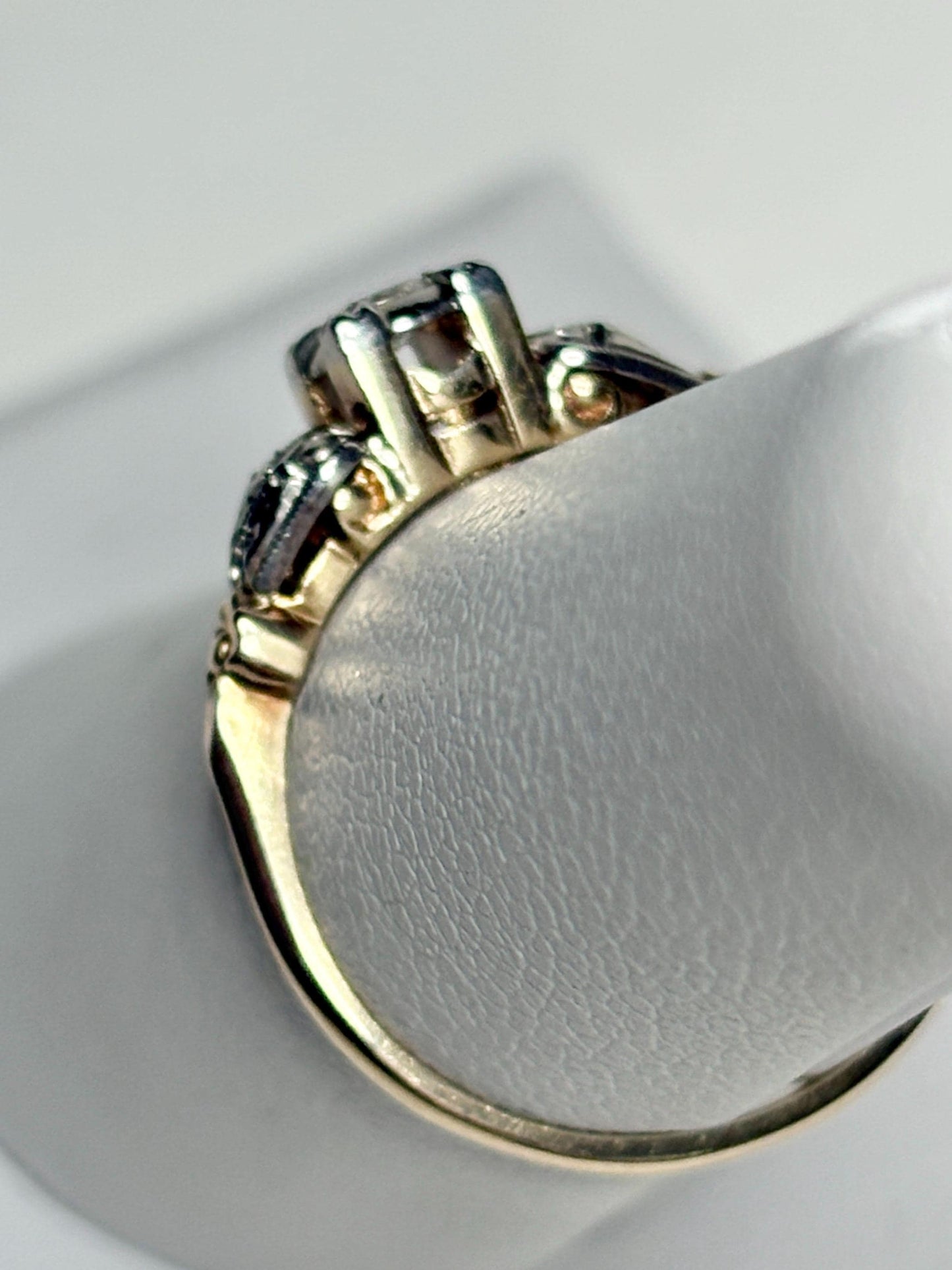 Vintage two-tone 14k gold ring with a central diamond and two side diamonds.