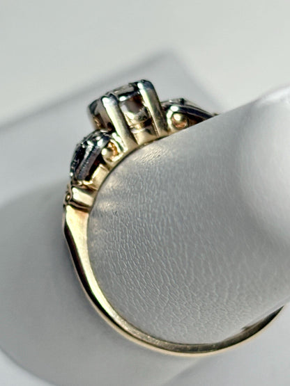 Vintage two-tone 14k gold ring with a central diamond and two side diamonds.