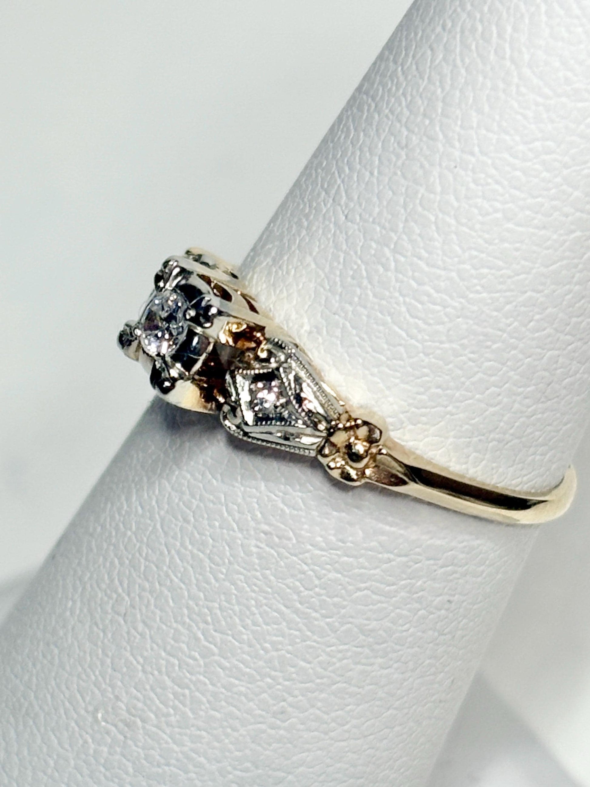Vintage 14k gold two-tone ring with a central diamond and two side diamonds.