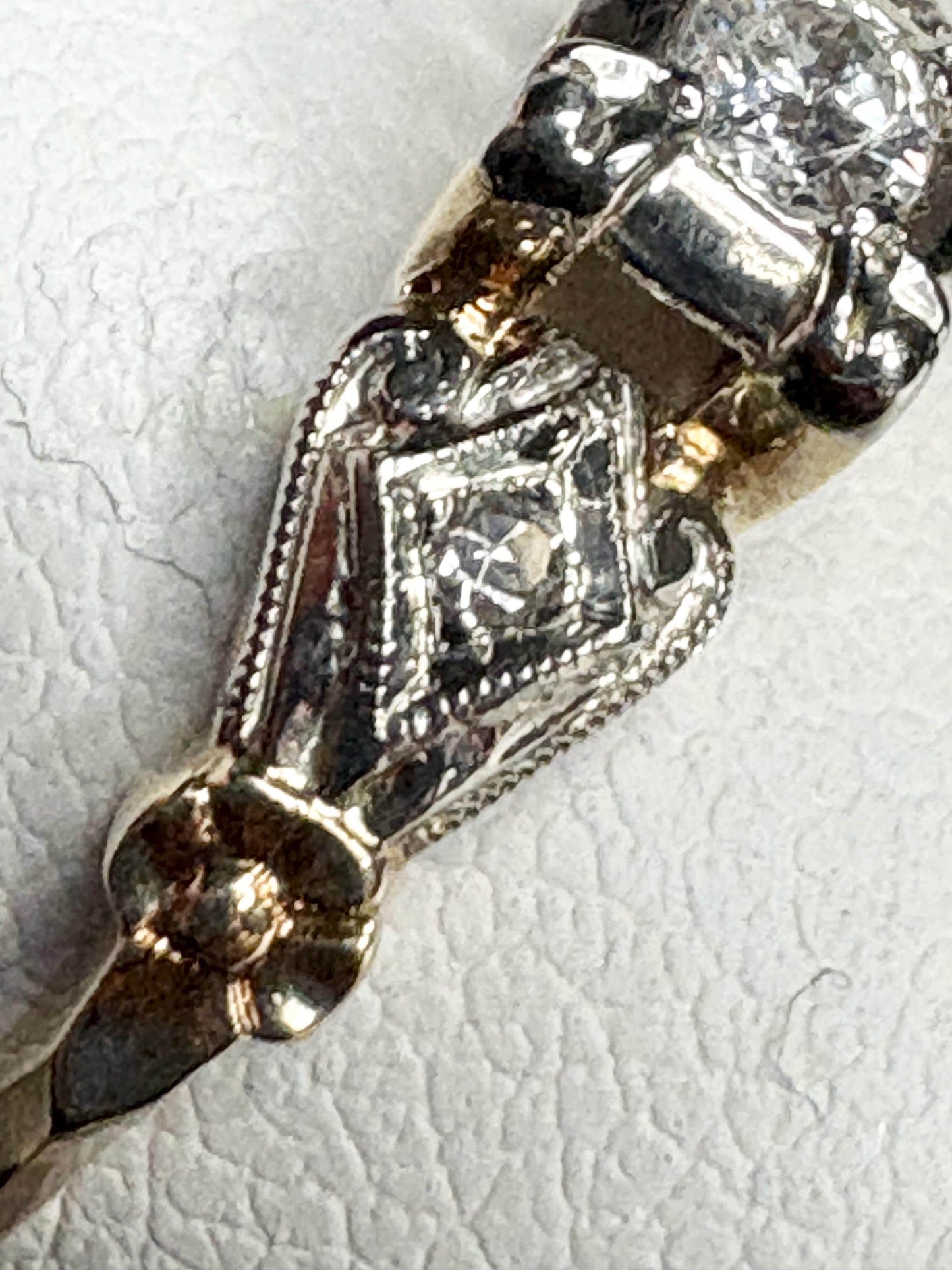 Vintage two-tone 14k gold ring with a central diamond and intricate detailing.