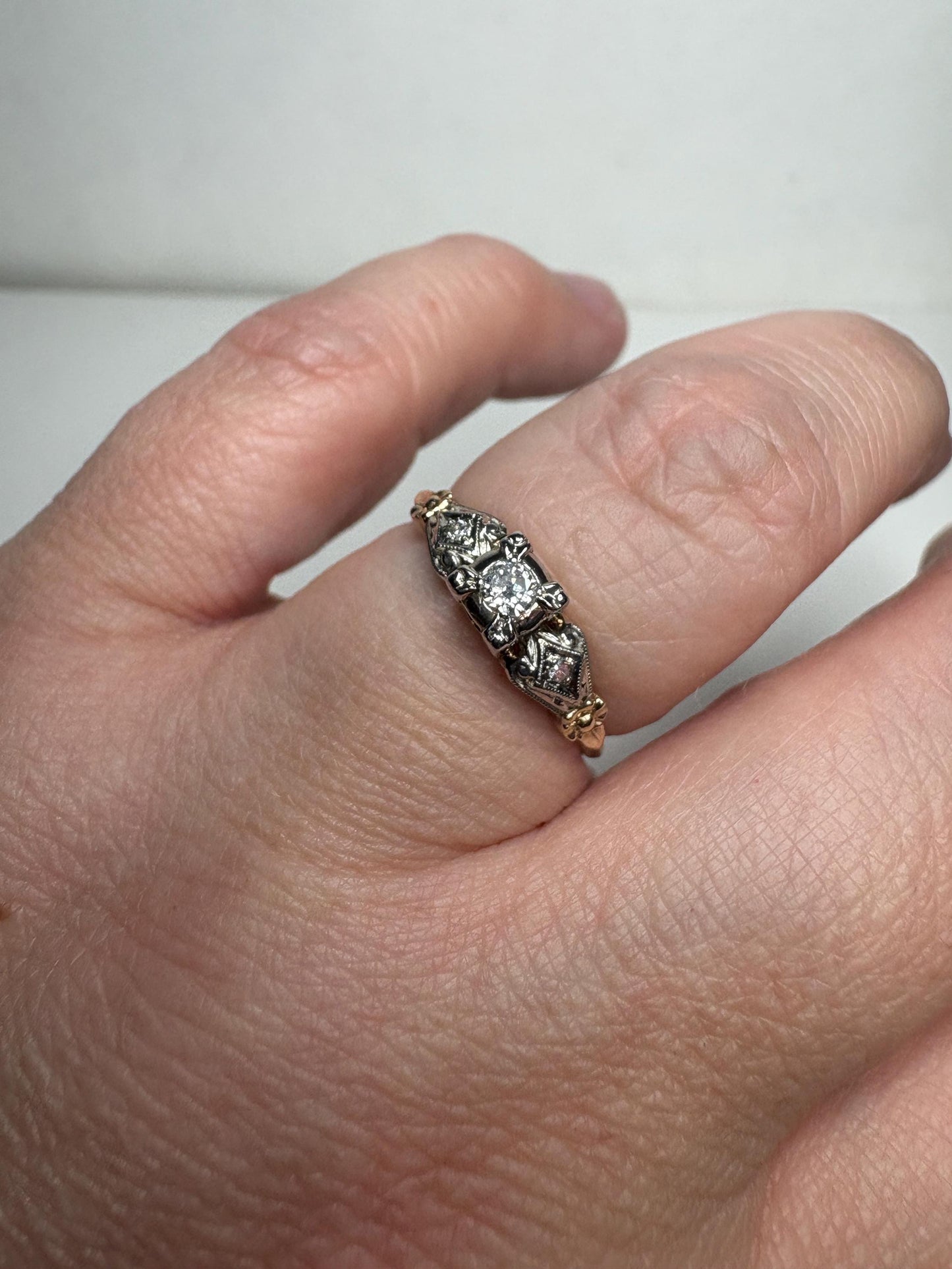 Vintage two-tone 14k gold ring with a central diamond and two smaller diamonds.