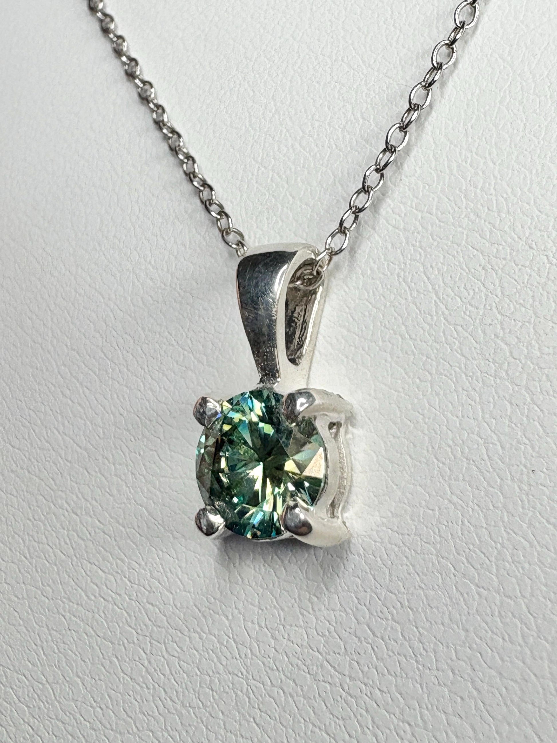 Sterling silver pendant necklace with a teal-green moissanite solitaire.