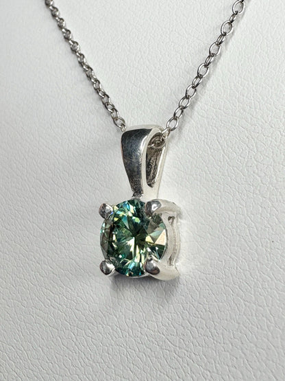 Sterling silver pendant necklace with a teal-green moissanite solitaire.
