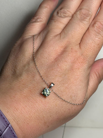 Teal-green moissanite solitaire pendant necklace in sterling silver.