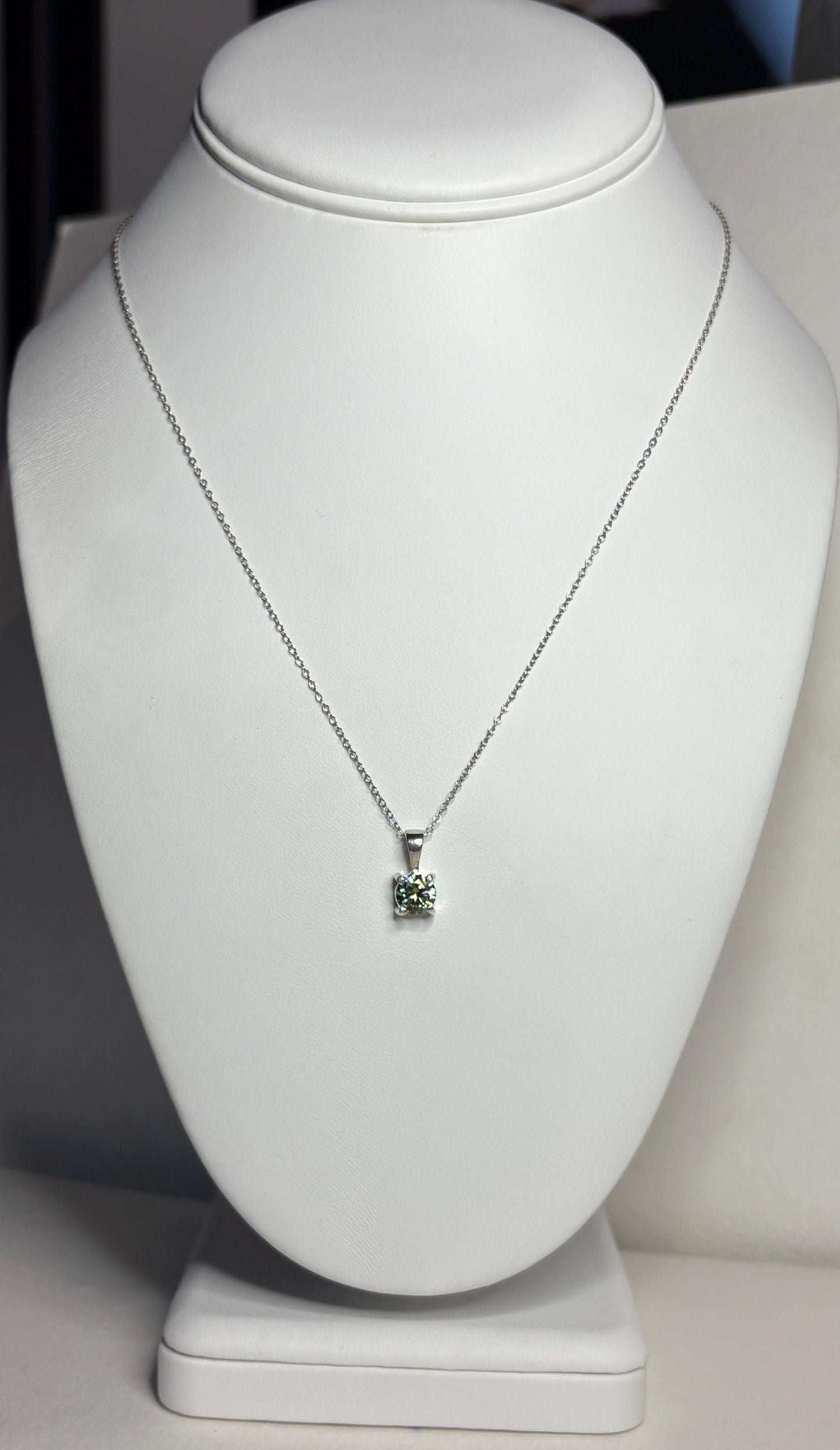 Teal-green moissanite solitaire pendant necklace on an 18-inch sterling silver cable chain.