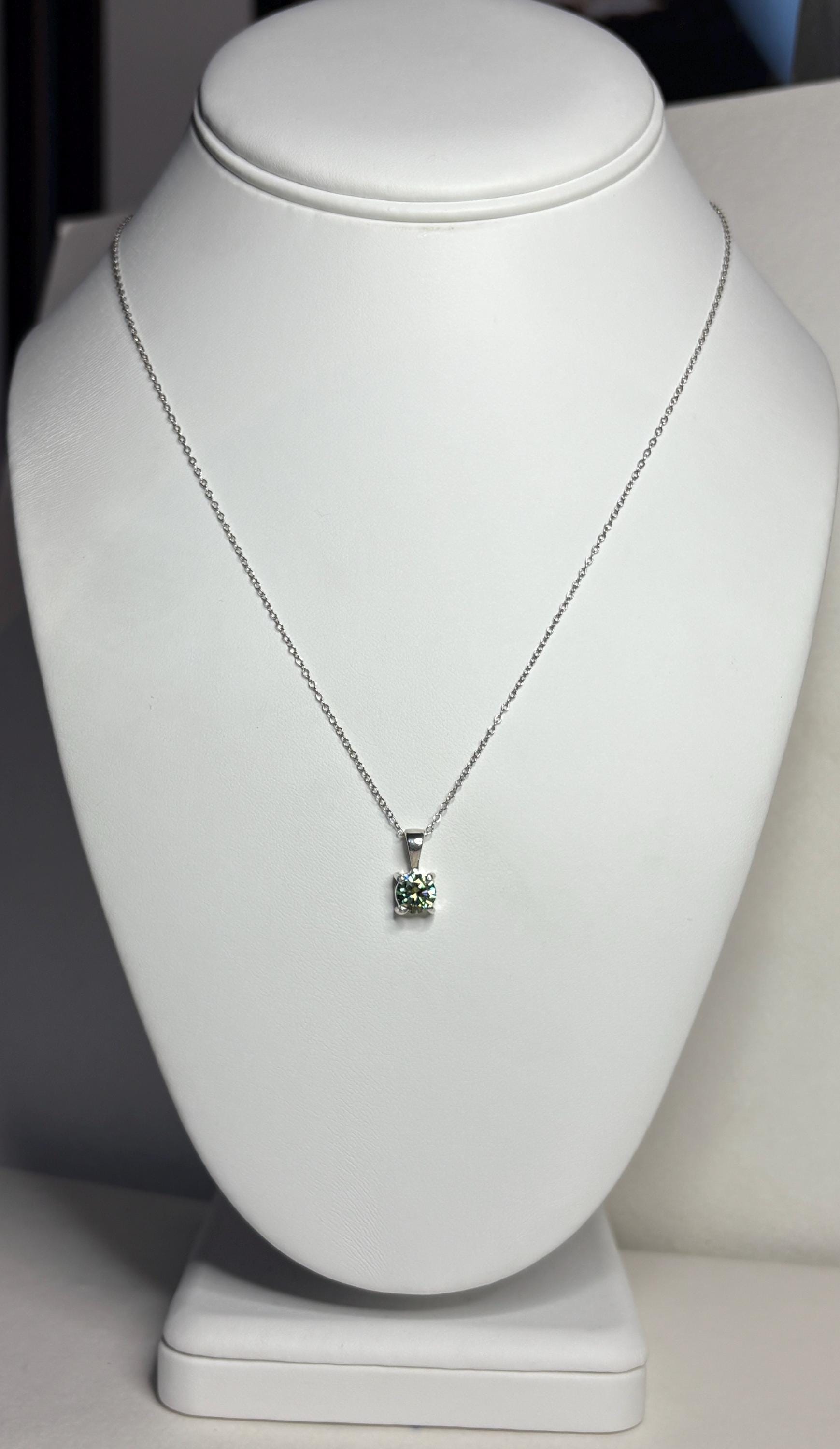 Teal-green moissanite solitaire pendant necklace on an 18-inch sterling silver cable chain.