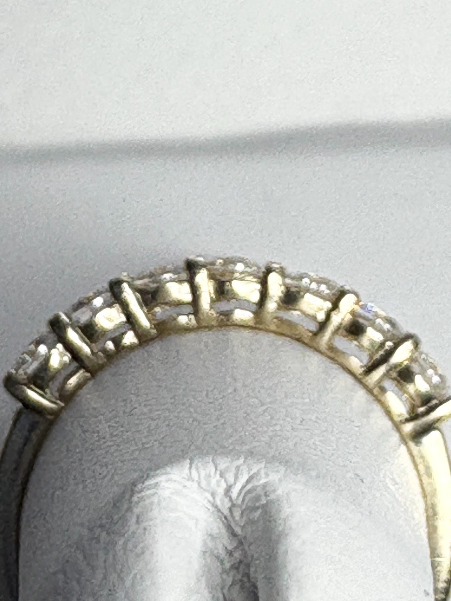 Solid 10k yellow gold band ring with seven moissanite stones.