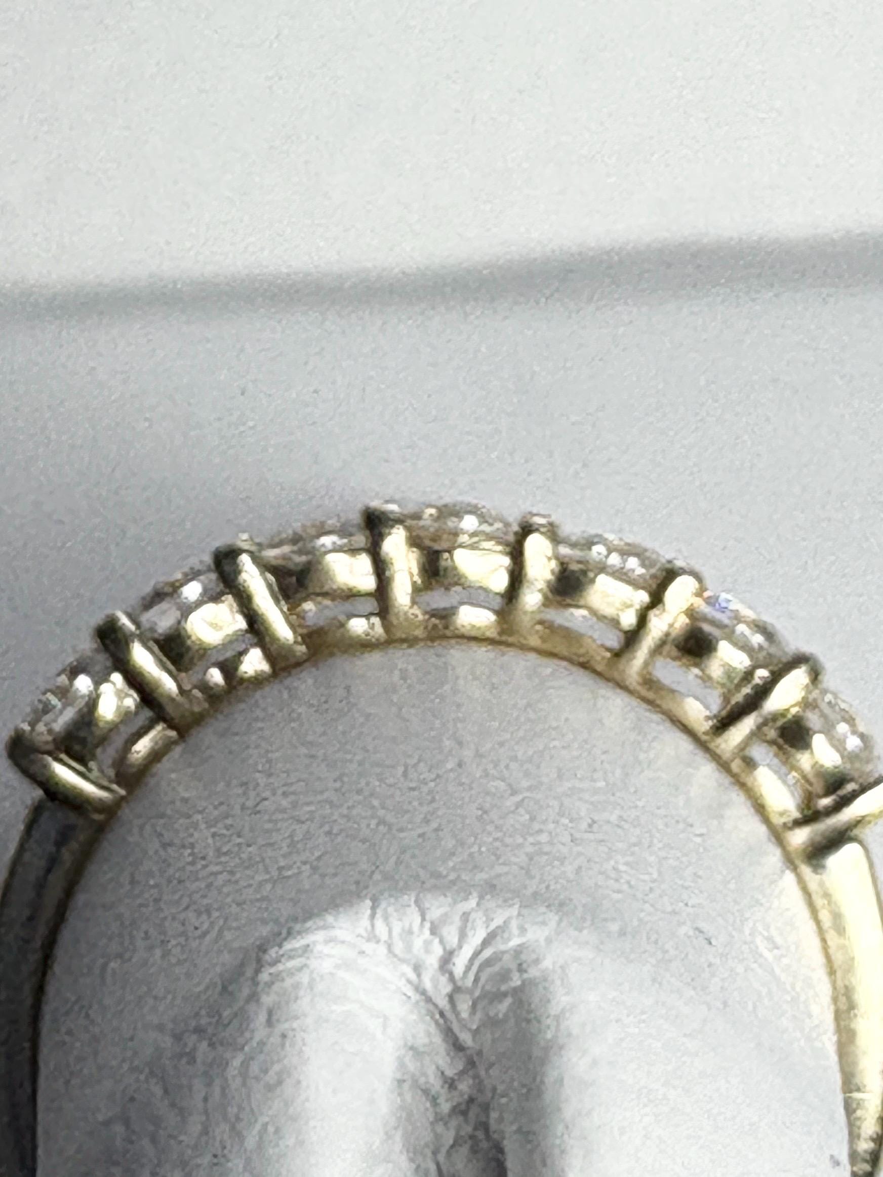 Solid 10k yellow gold band ring with seven moissanite stones.