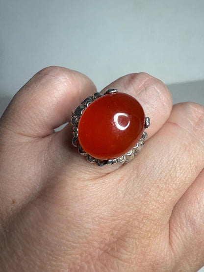 Sterling silver ring with a large, oval, orange carnelian cabochon.