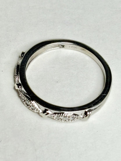A 10k white gold band ring with milgrain detailing and small diamonds.