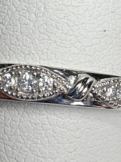 A 10k white gold band ring with milgrain detail and small diamonds.