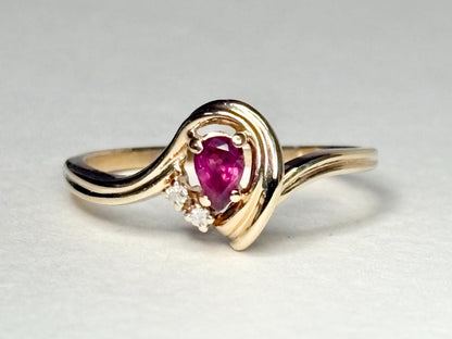 A 10k gold ring with a pear-shaped ruby and diamond accents.