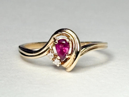 A 10k gold ring with a pear-shaped ruby and diamond accents.