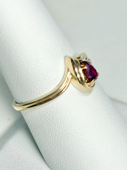 10k gold ring with a pear-shaped ruby and diamond accents.