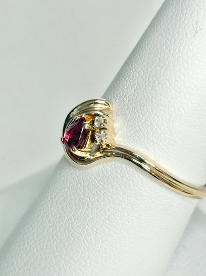 A 10k gold ring with a pear-shaped ruby and diamond accents.
