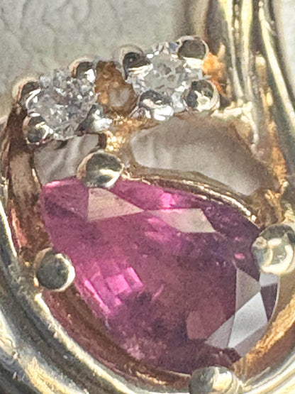 10k gold ring with a pear-shaped ruby and diamond accents.