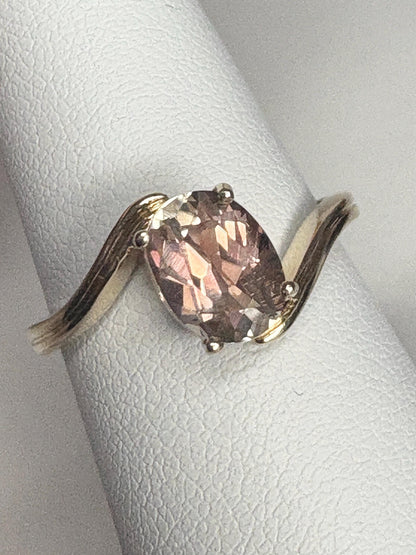 Oval light peach Oregon sunstone solitaire bypass ring in 14k gold.
